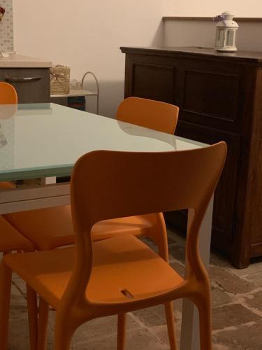 a kitchen with a table and two orange chairs at Il Sementone in Assisi