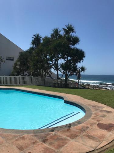 a swimming pool with the ocean in the background at 9 Casablance Ballito~Beach on your doorstep. in Ballito