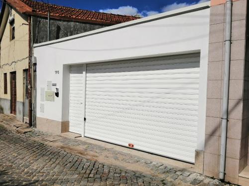 una puerta de garaje blanca en un edificio en una calle en Casa Ventuzelo, en Oporto