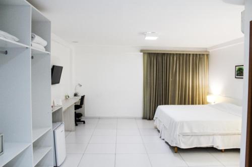una camera d'albergo con letto e scrivania di Imperial Hotel a Imperatriz