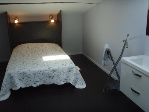 Dormitorio pequeño con cama y lavamanos en Loft du moulin de Milan en Cheval-Blanc