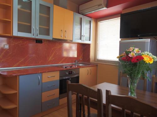 a kitchen with a table and a vase of flowers at Hotel Maria in Vratsa