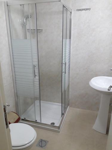 a bathroom with a shower and a toilet and a sink at Cypress Tree Apartments in Bethlehem