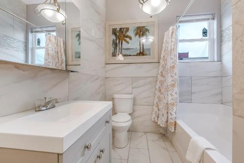 a bathroom with a sink and a toilet and a tub at Stunning Penthouse in the Heart of the City in New Orleans