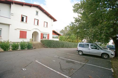 une voiture garée sur un parking devant un immeuble dans l'établissement T2 idéal curiste ou vacanciers au centre de Cambo, à Cambo-les-Bains