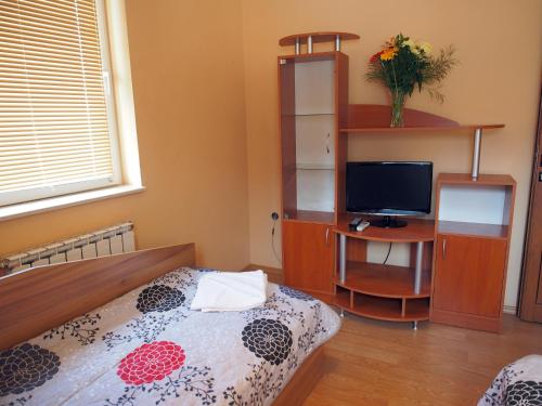 a bedroom with a bed and a desk with a television at Hotel Maria in Vratsa