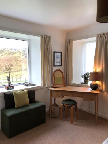 a room with a desk and a chair and a table at Harris White Cottage in Rodel