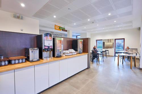 a restaurant with a counter and people sitting at tables at HI Brussels Generation Europe Hostel in Brussels