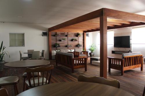 a restaurant with tables and chairs and a television at Terra do Chimarrão Hotel in Venâncio Aires