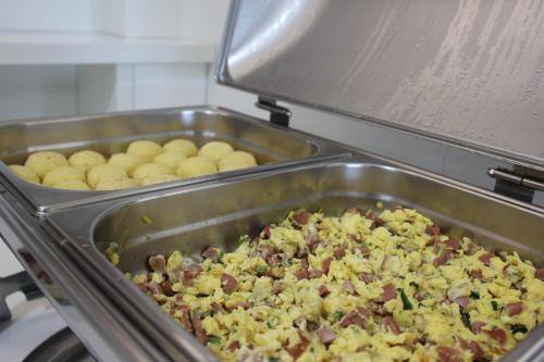 a metal pan filled with food in a kitchen at Terra do Chimarrão Hotel in Venâncio Aires