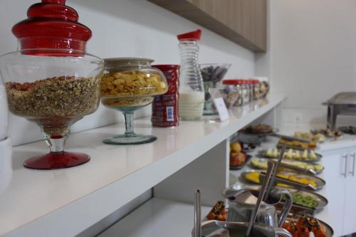 a kitchen counter with a shelf filled with food at Terra do Chimarrão Hotel in Venâncio Aires