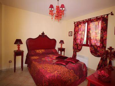 a bedroom with a red bed and a window at Résidence U MELU GRAND T3 ROUGE en rez de jardin in Tiuccia
