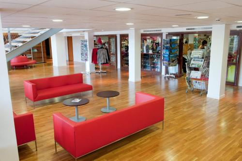 a store with two red couches and a table in the floor at Village Club Les Hyvans in Chorges