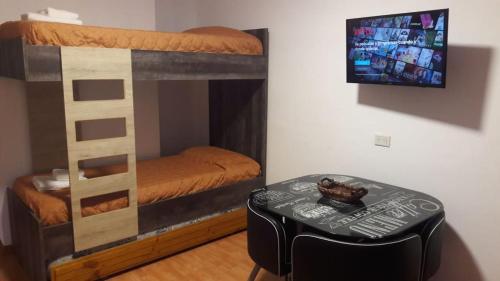 Zimmer mit einem Etagenbett und einem Tisch in der Unterkunft Departamento Estudio 2 in Neuquén
