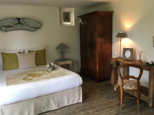a bedroom with a bed and a desk and a chair at Le Puits D'Angle in Thibivillers