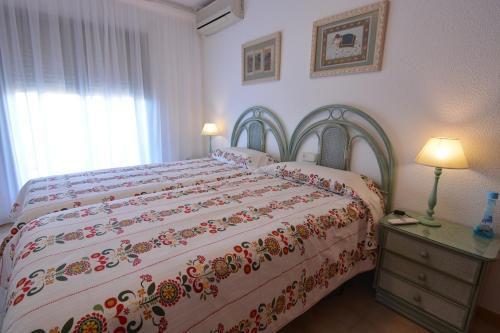 une chambre avec un grand lit avec un couvre-lit fleuri dans l'établissement Saval Cala Font, à Salou