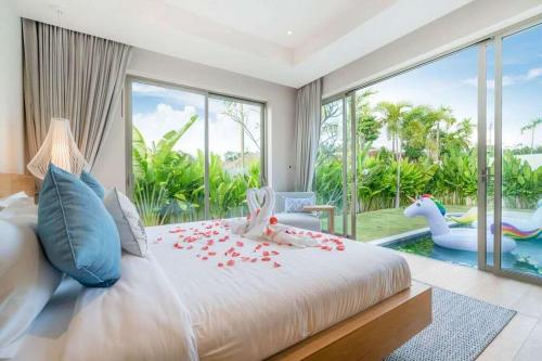 - une chambre avec un grand lit, une piscine et une chambre avec un hippopot dans l'établissement Trichada Tropical, à Bang Tao Beach