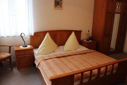 a bedroom with a wooden bed with yellow pillows at Villa Jagdhaus in Wernigerode