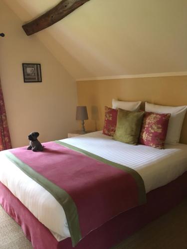a bedroom with a large bed with a teddy bear sitting on it at Le Puits D'Angle in Thibivillers