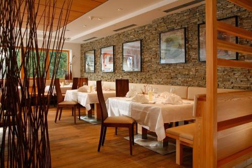 a restaurant with tables and chairs and a brick wall at Hotel Ratschingserhof in Racines