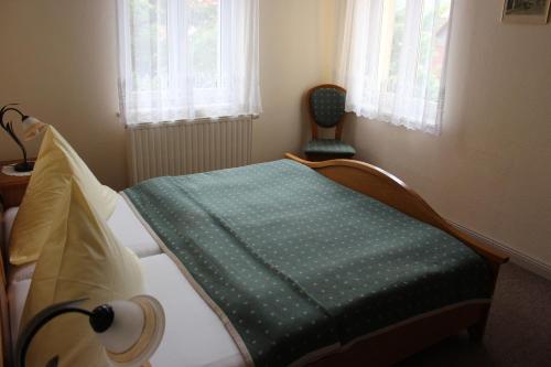 a bedroom with a bed with a green blanket on it at Villa Jagdhaus in Wernigerode