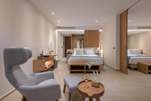 a hotel room with two beds and a chair at Gennadi Grand Resort in Gennadi