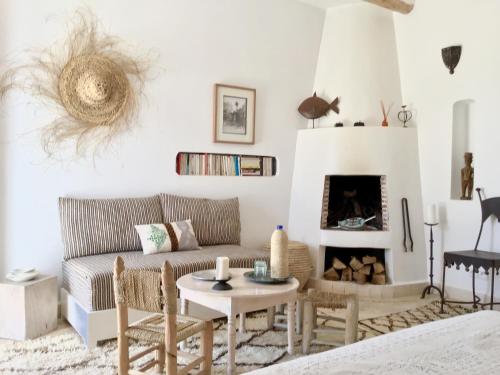 a living room with a couch and a fireplace at Dar Alya Essaouira Maison et table d'hôtes in Ghazoua