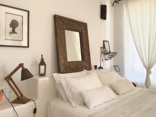 a bedroom with a bed with a mirror on the wall at Dar Alya Essaouira Maison et table d'hôtes in Ghazoua