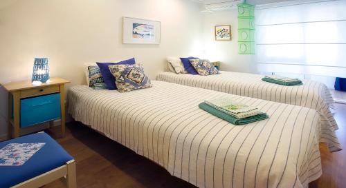 um quarto com duas camas com almofadas e uma mesa em Anjos 44 Lisbon Apartments em Lisboa
