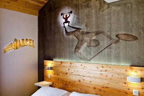 a bedroom with a wall with a painting on it at Anova Hotel & Spa in Montgenèvre
