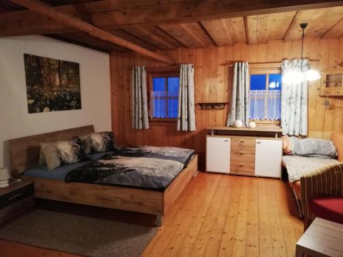ein Schlafzimmer mit einem Bett und einem Sofa in einem Zimmer in der Unterkunft Ferienwohnung Andrea in Bad Mitterndorf