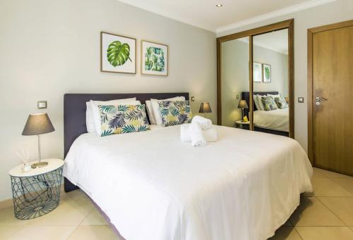 ルースにあるCantinho da Praiaのベッドルーム(大きな白いベッド1台、鏡付)