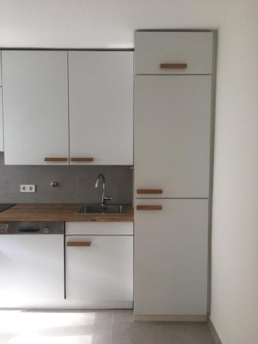 a kitchen with white cabinets and a sink at Ferienwohnung Börner ll in Kniebis