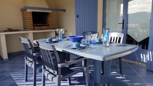 - une table à manger avec des chaises, une table blanche et un fauteuil dans l'établissement Résidence U MELU Grand T2 BLEU en rez de jardin, à Tiuccia