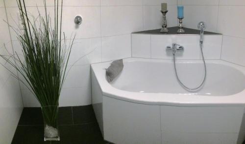 ein Badezimmer mit einer Badewanne und einem Waschbecken in der Unterkunft Möbliertes Apartment mit bestem Anschluss - Hangelar Mitte in Sankt Augustin