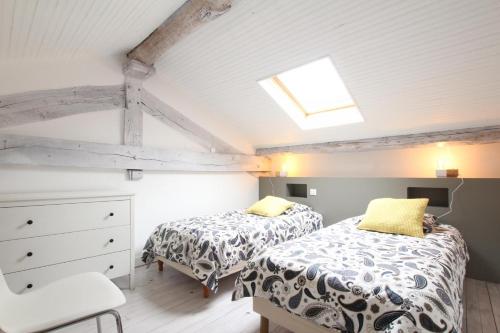 a attic bedroom with two beds and a skylight at Ferme Ithurburia in Saint-Michel