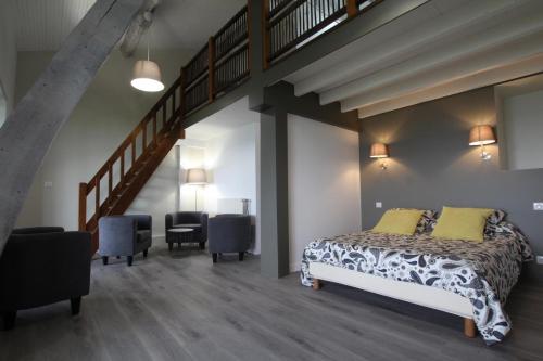 a bedroom with a large bed and a staircase at Ferme Ithurburia in Saint-Michel