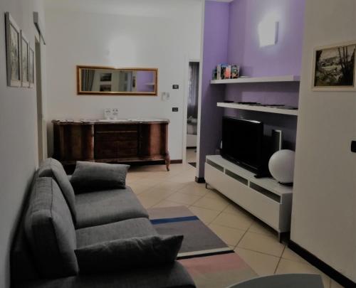 sala de estar con sofá y TV en Il Melograno, en Rímini