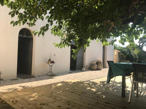 a patio with a table and chairs under a tree at A Loghja Di Cavallo Morto in Bonifacio