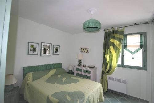 sypialnia z łóżkiem i oknem w obiekcie Résidence U MELU Grand T2 VERT à l'étage w mieście Tiuccia
