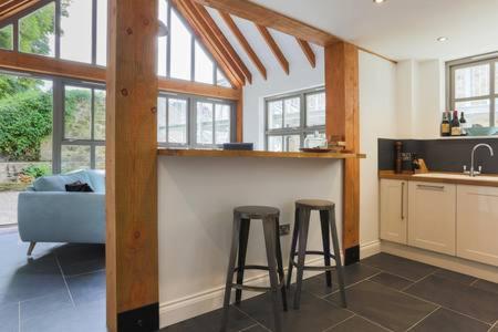 a kitchen with two stools and a bar in a room at The Engine House in Truro