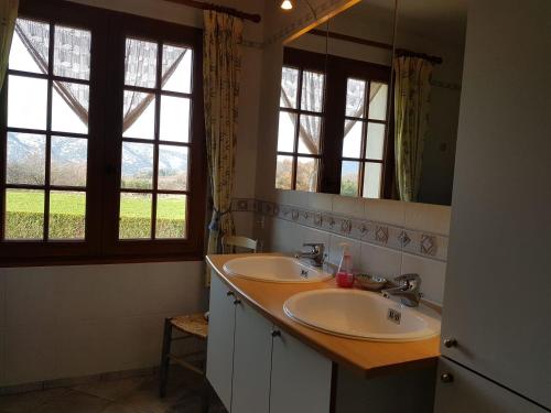 une salle de bain avec deux lavabos et un grand miroir dans l'établissement L'Abricotier, à Malaucène