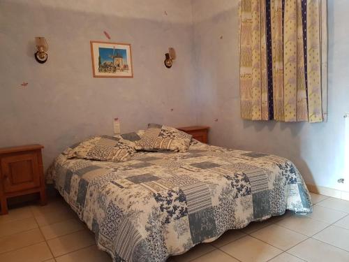 une chambre avec un lit avec une couette dessus dans l'établissement L'Abricotier, à Malaucène