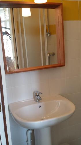 a white sink in a bathroom with a mirror at Au Pigeon Blanc in Andouillé