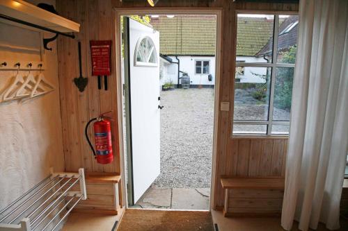 uma porta aberta para uma casa com um hidrante na porta em Stenrosgården em Kivik