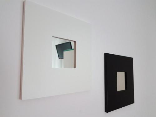 two pieces of art on a white wall at Hotel Nettuno in Porto San Giorgio