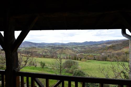 a view from a house window of a field and mountains at Ferme Ithurburia in Saint-Michel
