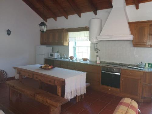 a kitchen with a table with a bowl of fruit on it at Azores Hibiscus House - Mountain and Sea in São Roque do Pico