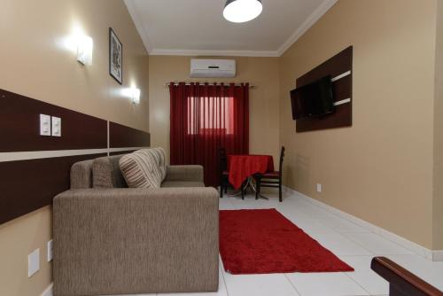 a living room with a couch and a red rug at Hotel São Bento in Marabá