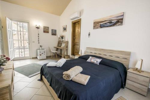 een slaapkamer met een groot bed en handdoeken bij b&b Lu Paradisu in Capo Mulini